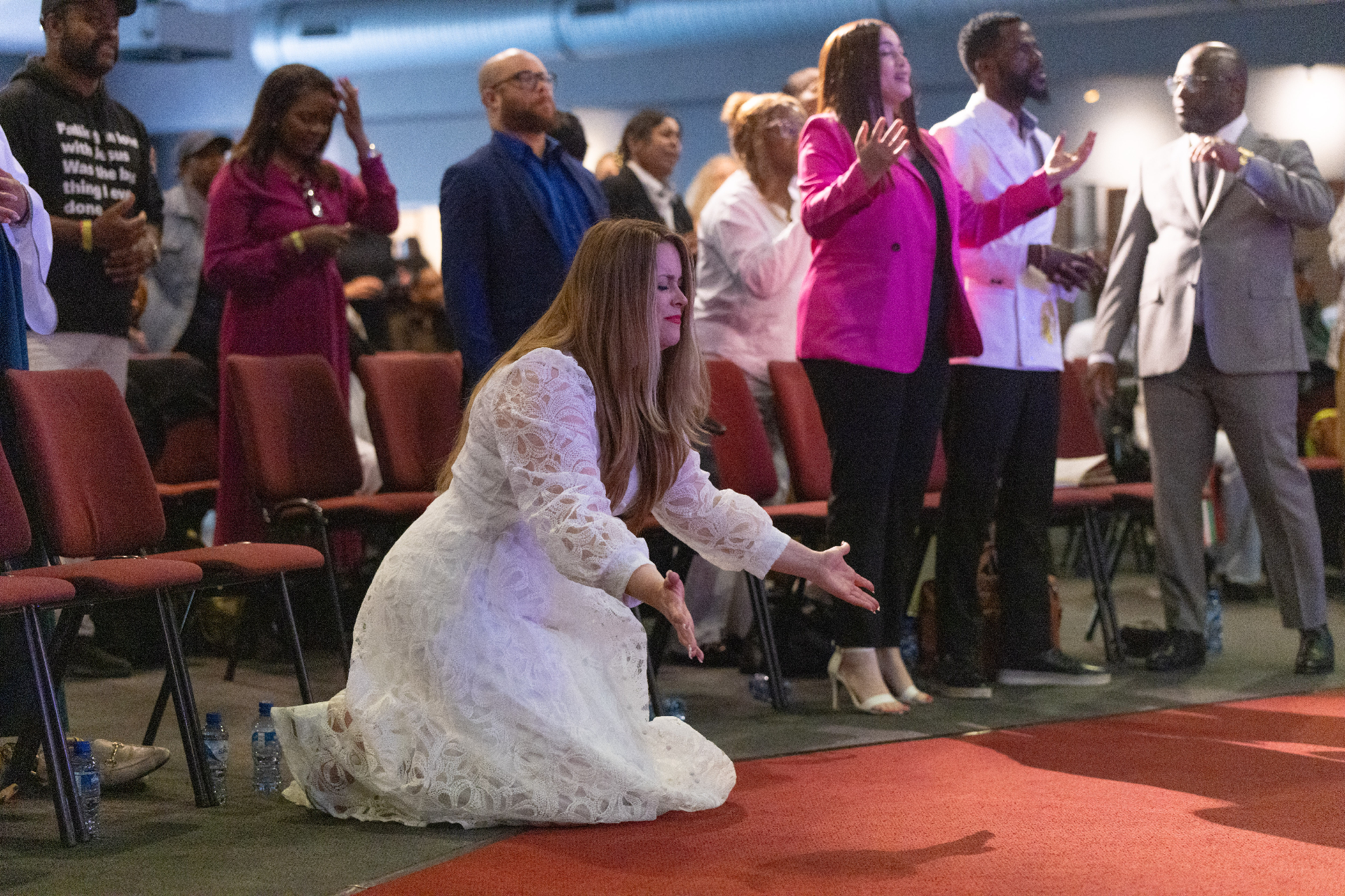 Debora kneeling in prayer with the congregation